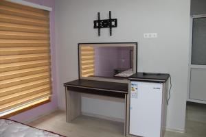 um quarto com uma mesa, um micro-ondas e um frigorífico em Hostel Asham em Panjakent