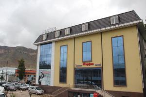 a building with cars parked in a parking lot at Hostel Asham in Panjakent