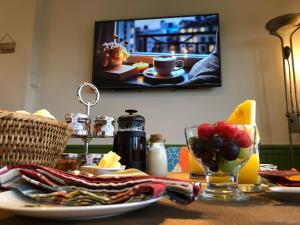 a table with a plate of food and a tv at The Old Farmhouse B&B in Dyffryn