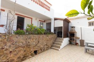 une maison avec un mur et des escaliers en pierre. dans l'établissement Casa Ardomar, à Carrapateira