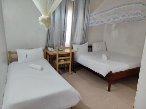 מיטה או מיטות בחדר ב-Garden Courts Hotel Masaka