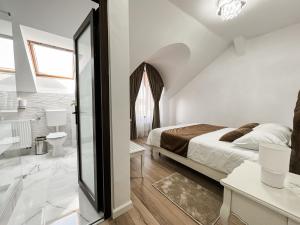 a bedroom with a bed and a bathroom at Complex Vila Rania in Satu Mare