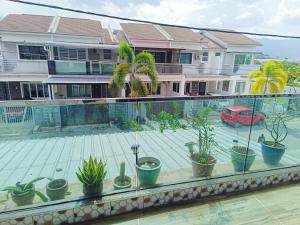 - un balcon avec des plantes en pot dans un bâtiment dans l'établissement perdana homestay, à Ipoh