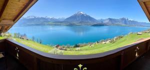 a view of a lake and mountains from a window at CHALET EGGLEN "Typical Swiss House, Best Views, Private Jacuzzi" in Sigriswil