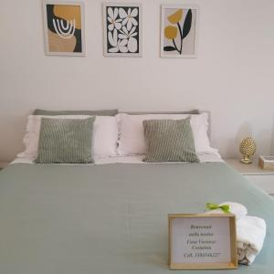 サンタ・マリア・ディ・カステッラバーテにあるCostamia Casa Vacanzeのベッドルーム1室(白いベッド1台、サイン付)