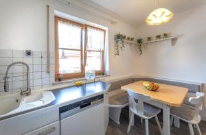eine Küche mit einem Waschbecken und einem Holztisch in der Unterkunft DREAM - Alpenblick, Balkon, Hängematte, Parkgarage in Kolbermoor