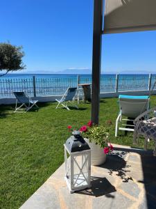 vista para o oceano a partir de um pátio com cadeiras e uma lanterna em Beachfront Villa Athina em Vergia