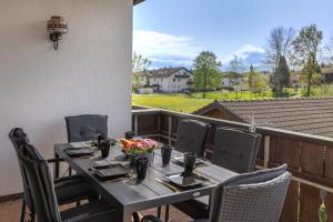 einen Tisch und Stühle auf einer Terrasse mit Blick auf ein Feld in der Unterkunft DREAM - Alpenblick, Balkon, Hängematte, Parkgarage in Kolbermoor