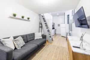 a living room with a couch and a tv at Ultimate Urban living at Centrally Located Lofts in New York