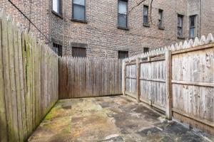 une clôture en bois devant un bâtiment en briques dans l'établissement Ultimate Urban living at Centrally Located Lofts, à New York