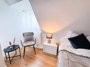 Dormitorio con silla, cama y lámpara en ThinkPink! Apartment Ennepetal * Sehr modern * Top Lage en Ennepetal