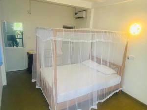 1 dormitorio con 1 cama con mosquitera en Charle's House Ahangama en Ahangama
