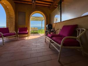 a room with two chairs and a table with purple cushions at Prestigious Home - Pool, Gazebo, and Stellar Views in Mazzolla
