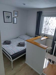 een slaapkamer met een bed, een bureau en een raam bij Ferienwohnung Grabner in Waging am See