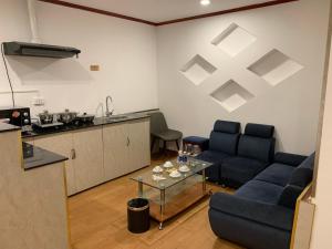 uma sala de estar com duas cadeiras azuis e uma mesa em A25 Hotel - 46 Châu Long em Hanói