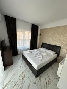 a bedroom with a large bed with marble floors at Casa Roma in Mamaia Nord +22 photos