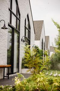 a white brick house with black windows and plants at Phuping Valley Resort in Tak