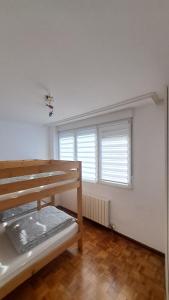 a white room with a bunk bed and two windows at Casa grande con jardín in Santa Cruz de Bezana