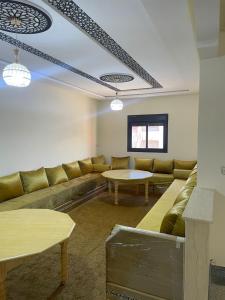 uma sala de estar com um sofá e duas mesas em Chez azrou em Azrou