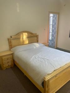 um quarto com uma grande cama de madeira e uma janela em Chez azrou em Azrou