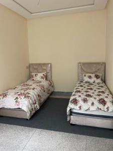 duas camas sentadas uma ao lado da outra num quarto em Chez azrou em Azrou