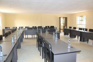 a room with tables and chairs with water bottles on them at RJ's Retreat Migwani Town in Kathera