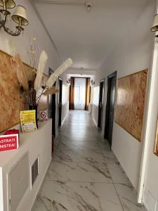 a corridor of a hotel with marble floors and walls at Casa Roma in Mamaia Nord