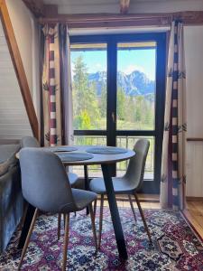 a table and chairs in a room with a large window at Villa Tatrydom in Zakopane