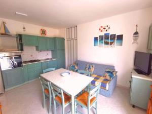 een keuken en een woonkamer met een tafel en een bank bij Platamoon Garden - with enchanting garden in Platamona