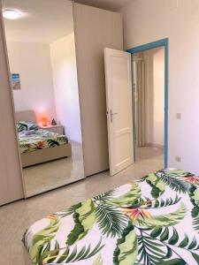 1 dormitorio con cama y espejo grande en Platamoon Garden - with enchanting garden, en Platamona