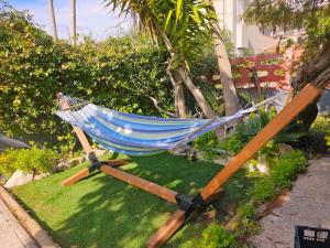 een hangmat op het gras in een tuin bij Platamoon Garden - with enchanting garden in Platamona