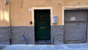 a green door on a building with two garage at La Casa di Dani in Genova