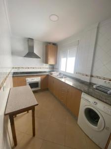 una cocina con lavadora y fregadero en Asís 20.7, en Medina Sidonia
