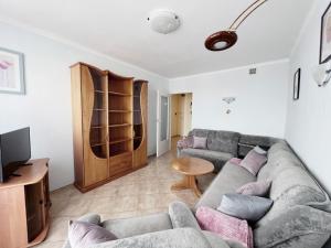 a living room with a couch and a tv at Apartament "Na fali" in Jarosławiec
