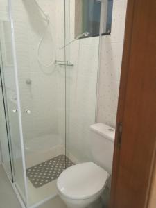 La salle de bains est pourvue de toilettes et d'une douche en verre. dans l'établissement Apartamento Studio Central, à Navegantes