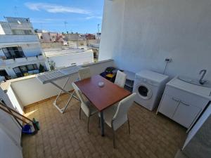 un piccolo balcone con tavolo e lavatrice di Infinity Residence con Parcheggio a Porto Cesareo