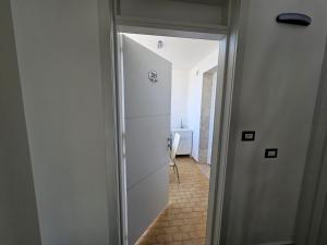 un corridoio con porta che conduce a una camera di Infinity Residence con Parcheggio a Porto Cesareo