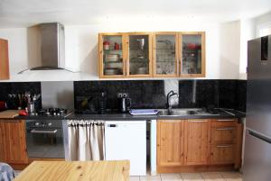 a kitchen with wooden cabinets and a sink at La Provençale .. in Valensole