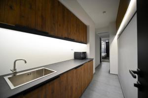 a kitchen with a sink and wooden cabinets at London Hotel Yerevan in Yerevan