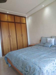 ラバトにあるBeautiful 3BR apartment in Hay Riad Rabatのベッドルーム(大型ベッド1台、木製キャビネット付)