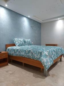 ラバトにあるBeautiful 3BR apartment in Hay Riad Rabatの青い壁のベッドルーム1室