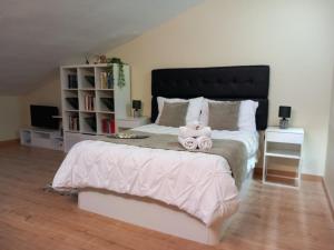 a bedroom with a large bed with a teddy bear on it at Atico Mary in Aguilar de Campóo