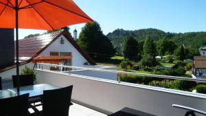- Balcón con mesa y sombrilla en Ferienwohnung Frenzel en Kurort Gohrisch