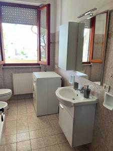 łazienka z umywalką, toaletą i lustrem w obiekcie Casa Palma - 300mt dal Mare w mieście Marina di Massa +9 zdjęć
