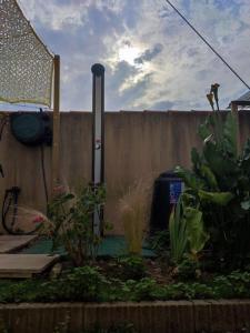 a backyard with a fence and a garden with plants at tiny house in Les Sorinières