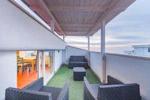 a balcony with chairs and a table on a roof at Orizzonte in blu in Anzio