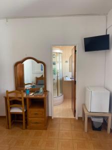 a room with a desk and a mirror and a sink at Pensão Dona Ana in Lagos
