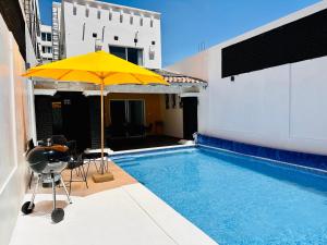 un parasol jaune assis à côté d'une piscine dans l'établissement Casa Rinconcito Del Sol Con Alberca, à Tonatico