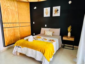 - une chambre avec un lit et une couverture jaune dans l'établissement Casa Rinconcito Del Sol Con Alberca, à Tonatico