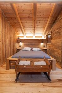 - une chambre avec un lit dans une cabane en bois dans l'établissement Casa Vacanze I Foresti C'A D'Arte, à San Damiano Macra